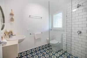 a white bathroom with a toilet and a sink at Barbara's Byron Bay in Byron Bay +77 photos