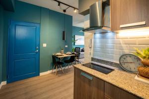 a kitchen with a blue door and a dining room at Apartamento Moderno Panamá 02 in Panama City