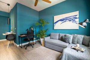 a living room with blue walls and a couch and a desk at Apartamento Moderno Panamá 02 in Panama City