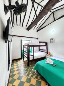 a bedroom with two bunk beds and a checkered floor at Green Door San Gil in San Gil