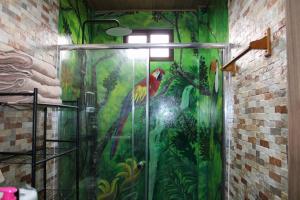 a bathroom with a shower with a painting of a parrot at Casa Cabaña En San Carlos Panamá in San Carlos