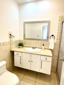 a bathroom with a sink and a mirror and a toilet at Hermosa villa en Palma Real in La Ceiba