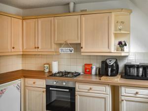 a kitchen with wooden cabinets and a stove top oven at The Old School in Cleethorpes