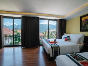 a hotel room with two beds and a large window at Ladybird Sapa Hotel in Sa Pa