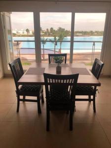 a dining room table and chairs with a view of the water at Departamento, Laguna y Albercas en Dream Lagoons Veracruz in Veracruz