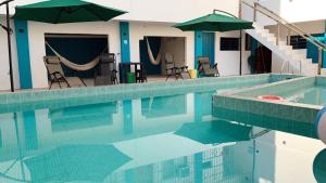 a swimming pool with chairs and umbrellas next to at Hotel Las Brisas in Catemaco