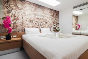 a bedroom with a large bed with a wall mural at Tao Resort and Villas (SHA Extra+) in Phuket Town