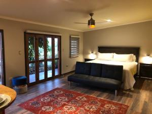 a bedroom with a bed and a couch in it at Strip Center Suites by Casona Lo Aguirre in El Monte