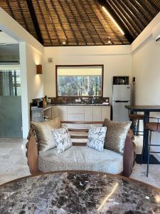 a living room with a couch and a kitchen at Seaside Villa Kecil in Sekotong