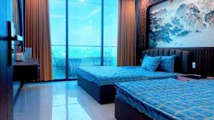 Cette chambre comprend deux lits et une grande fenêtre. dans l'établissement Villa Mũi Né Summerland 4PN 0.8.2.7.7.4.0.0.3.3, à Ấp Phú Tịnh (2)