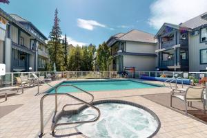 a swimming pool with a hot tub in a yard at Ski-in Ski-out at upper village next to Fairmount Hotel In Whistler in Whistler