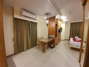 Una habitación de hotel con una cama y un escritorio en una habitación en The Signature Hotel @ Thapae en Chiang Mai