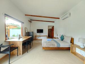 a bedroom with a bed and a desk and a table at Island World Panglao in Panglao Island