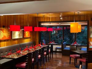 モンテベルデ・コスタリカにあるTrapp Family Lodge Monteverdeのダイニングルーム(テーブル、椅子、赤いランプ付)