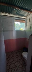 uma casa de banho com um WC e uma janela em Pak Mus Guest House Ketambe - 0813-7072-1793 em Kutacane