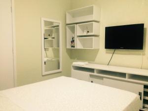 a white room with a tv and a bed at Farol Barra Flat completo e bem localizado in Salvador
