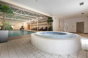 a large pool with a large tub in the middle of a building at Holiday Inn Guildford by IHG in Guildford