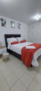 1 dormitorio con 1 cama grande con manta roja en C&G Home Perú en Lima