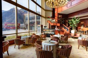 een restaurant met tafels en stoelen en een groot raam bij KensingtonHotel Seorak in Sokcho