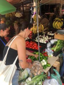 uma mulher em frente a um mercado com vegetais em Hostel ZwiebeL em Santa Ana