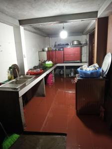 a kitchen with red cabinets and a red floor at Eco Joville House - Sapa Homestay in Sa Pa