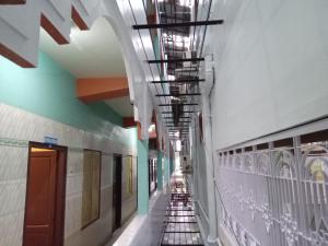 um corredor num edifício com escadas rolantes e tectos em Royal Rasool Residency em Paramagudi