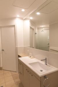a bathroom with a sink and a mirror at Beaches Holiday Apartments with Onsite Reception & Check In in Port Douglas