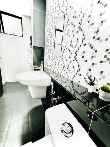 Un baño con un inodoro blanco y un lavabo. en Aira Suite JB Near CIQ, en Johor Bahru