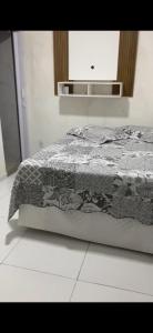 een slaapkamer met een bed met een zwart-witte quilt bij Casa com Piscina, hidromassagem e churrasqueira. in Canoa Quebrada