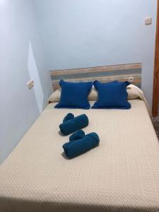 a bed with blue pillows and blue pillows on it at Casa Chorreón in Letur