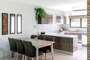 a kitchen and dining room with a wooden table and chairs at Glen Eden Beach Resort in Peregian Beach
