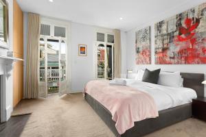 een slaapkamer met een groot wit bed en een aantal ramen bij Modern, Elegant Oasis - Trendy Area - Free Parking in Sydney