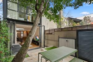 een groene bank naast een boom bij Modern, Elegant Oasis - Trendy Area - Free Parking in Sydney