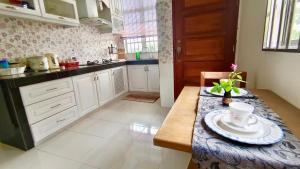 uma cozinha com armários brancos e uma mesa com um prato em Homestay Baitus Soleh Batu Buruk em Kuala Terengganu