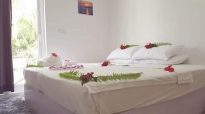 una cama blanca con adornos de Navidad encima en Small Island Lodge, en Vaadhoo