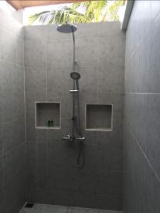 a shower with a shower head in a bathroom at Small Island Lodge in Vaadhoo