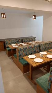 a dining room with tables and chairs with plates on them at Hotel Sherabling in Gangtok