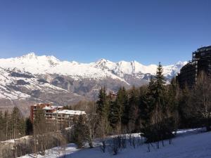 a snowy mountain range with a building in the foreground at Nice Flat Le Varet Arcs 2000 in Arc 2000