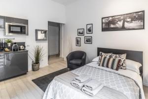 um quarto branco com uma cama e uma cadeira em MilanRentals - Tarra Apartment em Milão