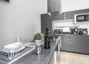 uma cozinha com uma mesa com garrafas de vinho e copos em MilanRentals - Tarra Apartment em Milão