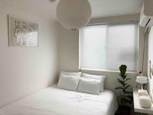 biała sypialnia z łóżkiem i oknem w obiekcie NEW 2F super cozy 2BR 5min station stay contigo w Seulu