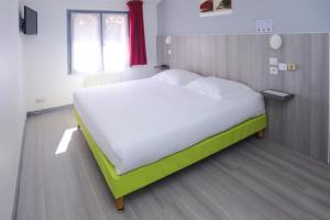 1 dormitorio con 1 cama grande con sábanas blancas en Hôtel Le Cheval Blanc, en Saint-Maixent-lʼÉcole