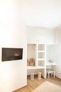 a living room with white cabinets and a flat screen tv at RODAVGI APARTMENTS in Andros