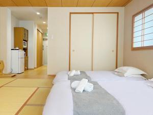 um quarto com 2 camas e toalhas em 千間川ー天王寺 em Osaka