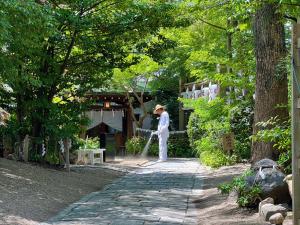 Um homem está de pé num caminho num jardim em 千間川ー天王寺 em Osaka