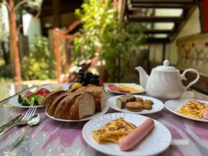 Una mesa con platos de comida para desayunar. en Green House ECO HOTEL, en Samarkand