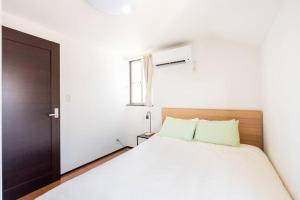 Ένα ή περισσότερα κρεβάτια σε δωμάτιο στο FUJIMI TOWN HOUSE
