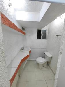 a white bathroom with a toilet and a sink at Departamento Amueblado Parque Toluca 2000 in Santín