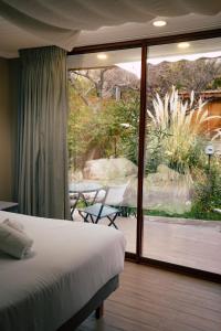 a bedroom with a bed and a view of a patio at Hotel El Tesoro de Elqui in Pisco Elqui