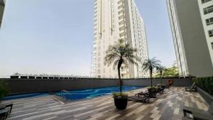 a large building with a swimming pool in a city at Apartemen Galeri Ciumbuluit 3 in Bandung
